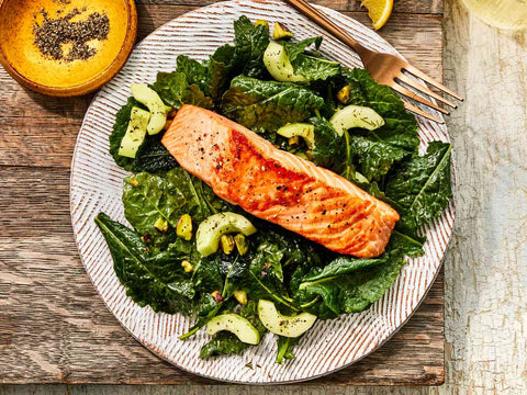 Seared wild salmon fillet served over kale and avocado